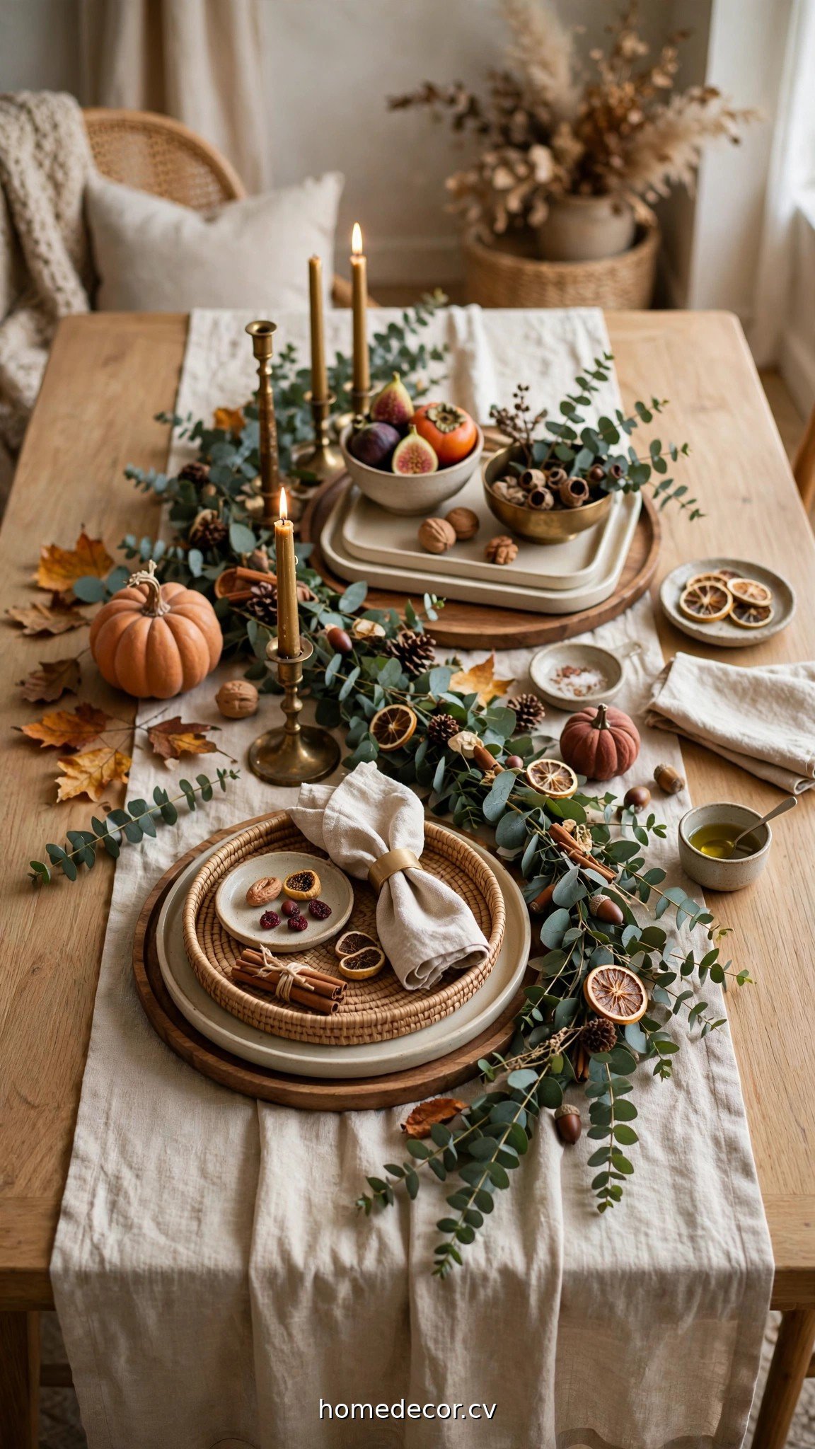 Styled fall table with a linen runner, eucalyptus garland and layered trays